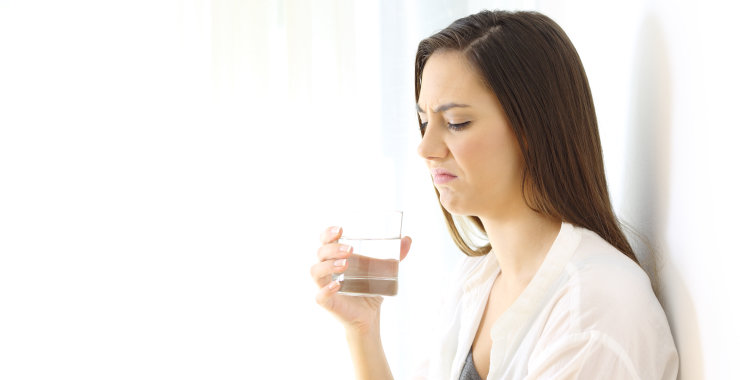 disgusted woman drinking water with bad taste